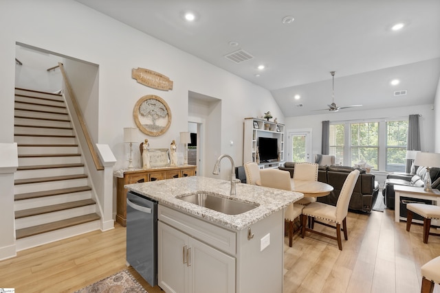 kitchen featuring a center island with sink, sink, vaulted ceiling, stainless steel dishwasher, and ceiling fan