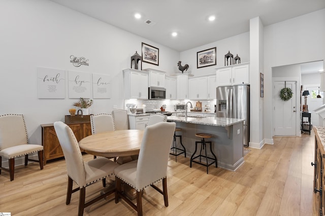 dining space featuring light wood-type flooring and sink