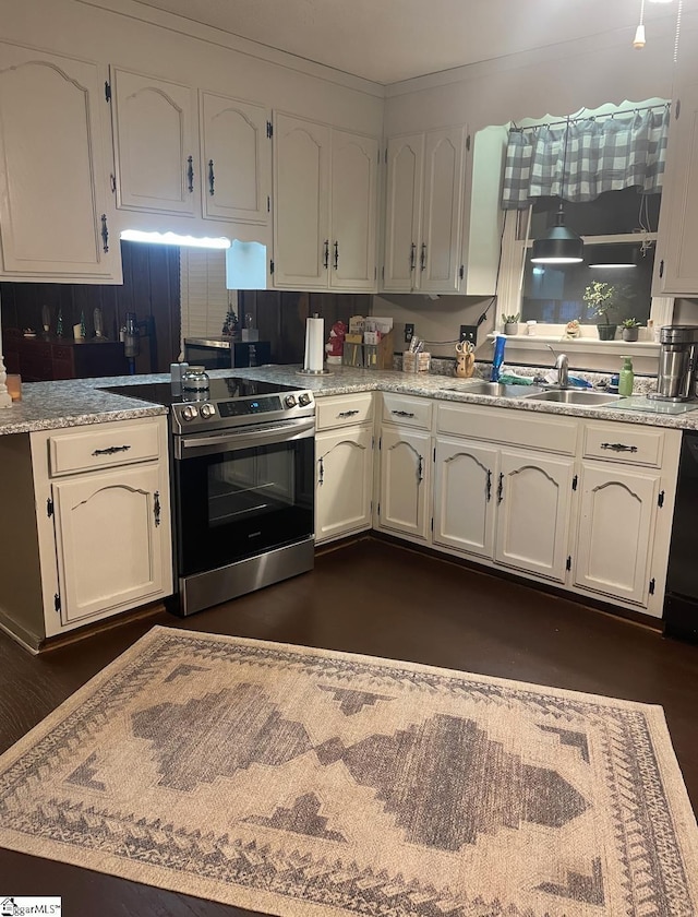 kitchen with electric range, white cabinetry, ornamental molding, and sink