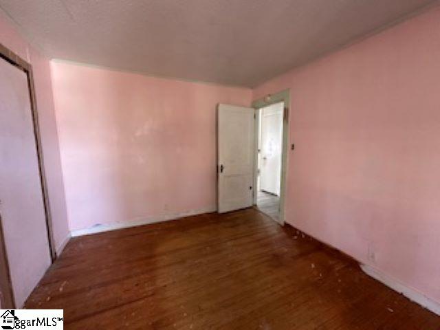 unfurnished room with dark hardwood / wood-style flooring