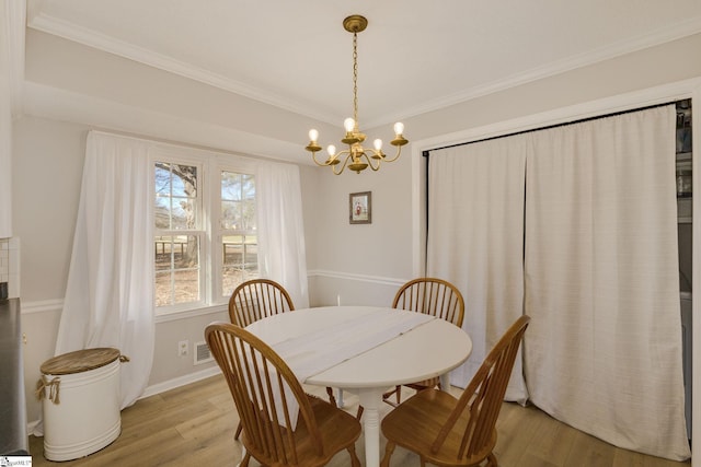 dining room featuring light hardwood / wood-style floors, an inviting chandelier, and ornamental molding