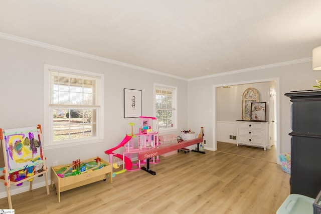 game room with light wood-type flooring and ornamental molding