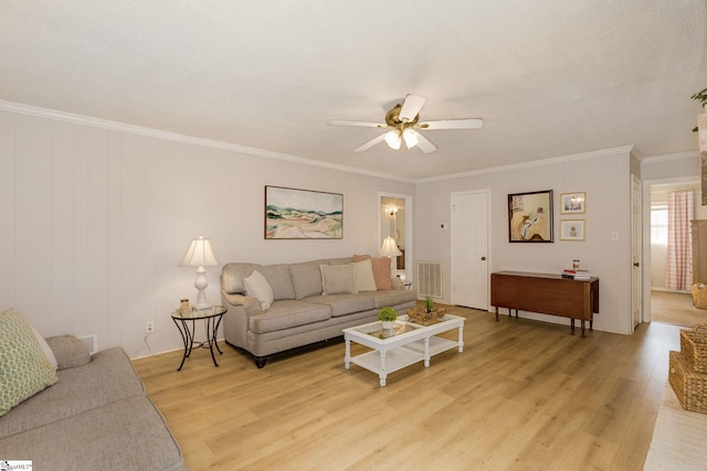 living room featuring light wood-type flooring, ceiling fan, and ornamental molding