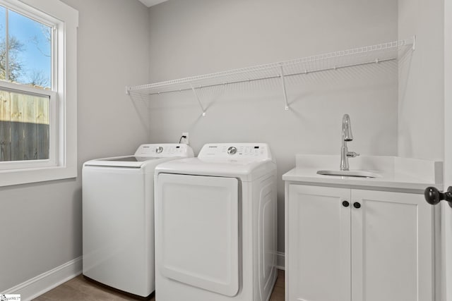 washroom featuring cabinets, washing machine and dryer, and sink