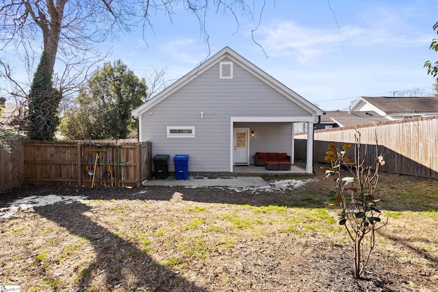 back of property with a patio area, an outdoor living space, and a yard