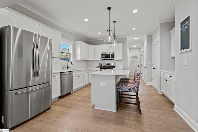 kitchen with a kitchen island, sink, white cabinetry, and stainless steel appliances