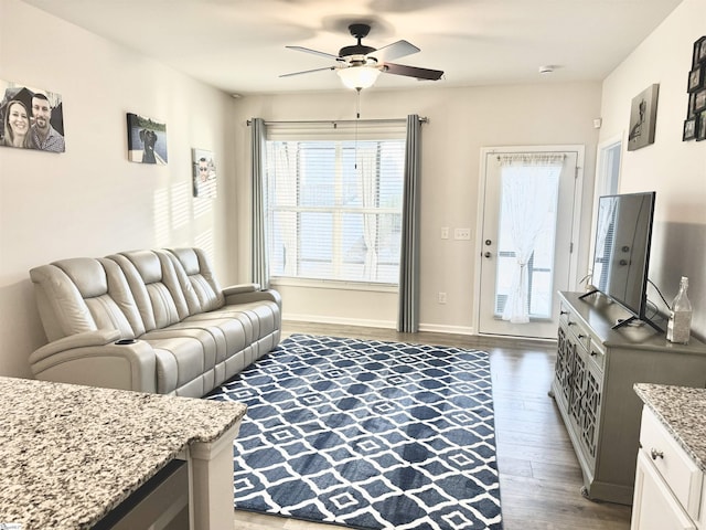 living room with ceiling fan and dark hardwood / wood-style floors