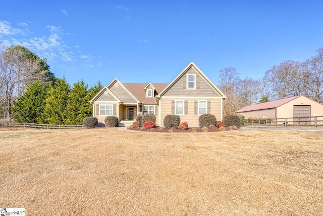 view of front of house featuring a garage, a front lawn, and an outdoor structure