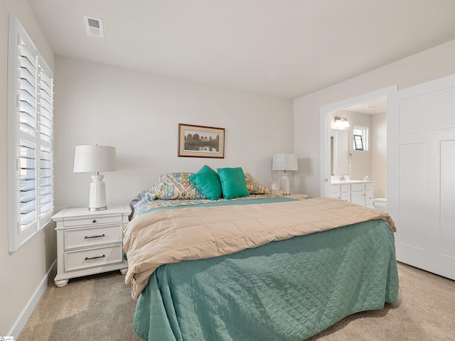 bedroom with ensuite bath and carpet