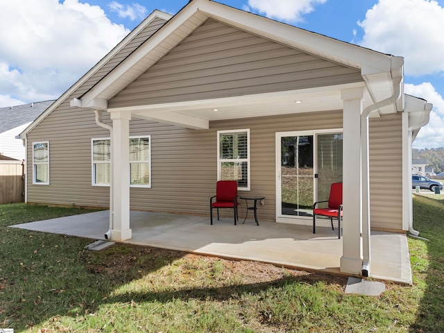 rear view of house with a lawn and a patio area