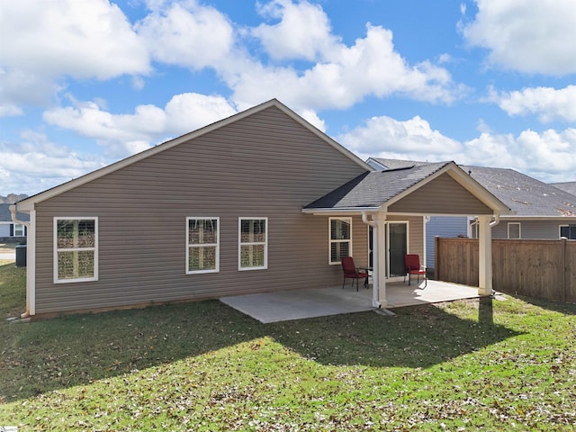 back of property with a lawn and a patio area