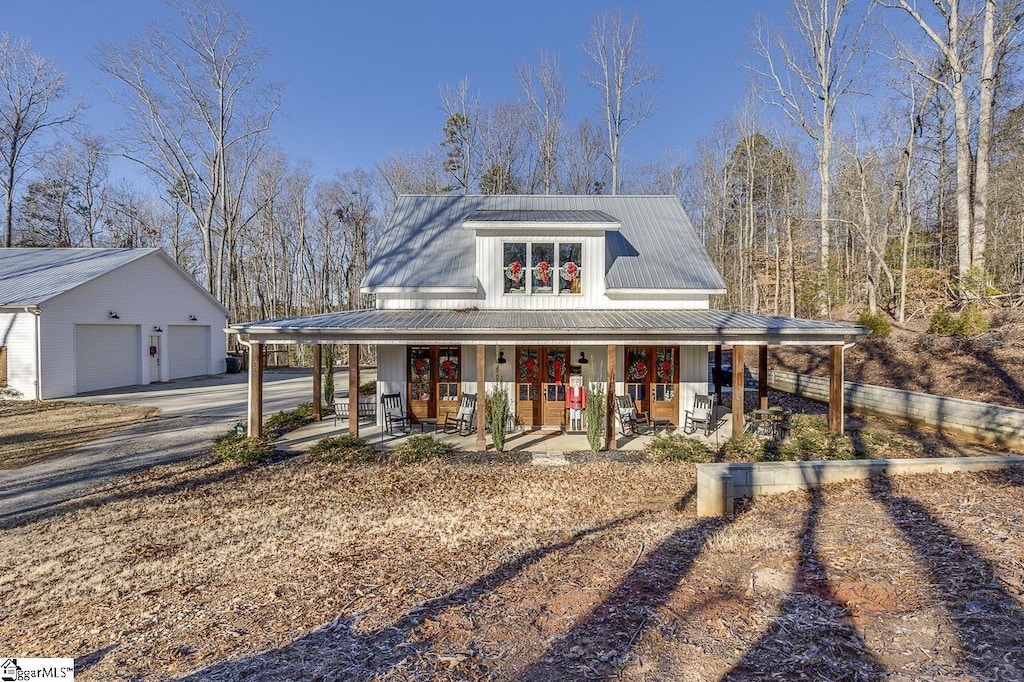 view of front of property featuring an outbuilding, a porch, and a garage