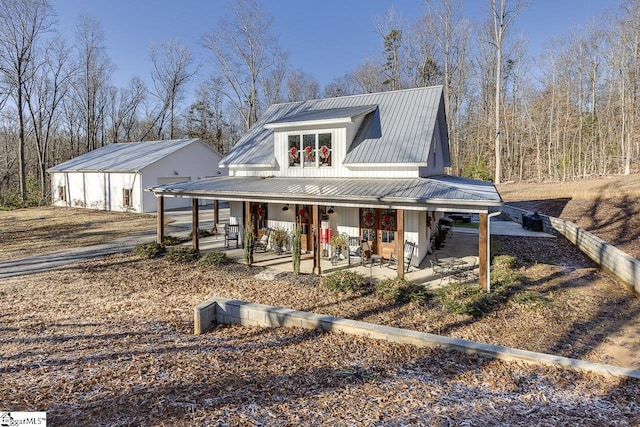 view of front facade featuring an outbuilding, covered porch, and a garage