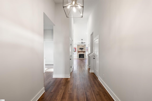 hallway featuring dark hardwood / wood-style floors, a high ceiling, and an inviting chandelier