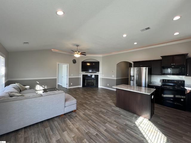 living room with ceiling fan, dark hardwood / wood-style flooring, and crown molding