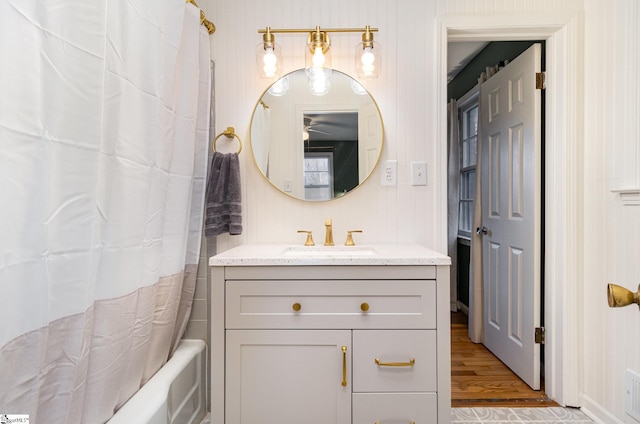 bathroom with hardwood / wood-style flooring, vanity, wood walls, and shower / tub combo with curtain