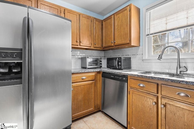 kitchen with decorative backsplash, light tile patterned flooring, sink, and stainless steel appliances