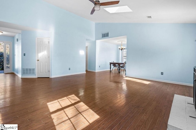 unfurnished living room featuring a skylight, ceiling fan with notable chandelier, dark hardwood / wood-style floors, and high vaulted ceiling