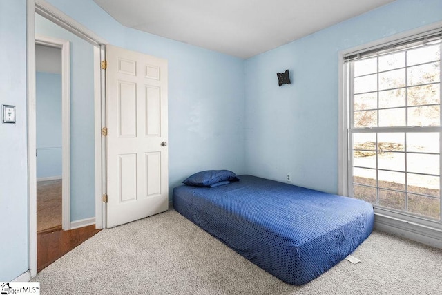 carpeted bedroom featuring multiple windows