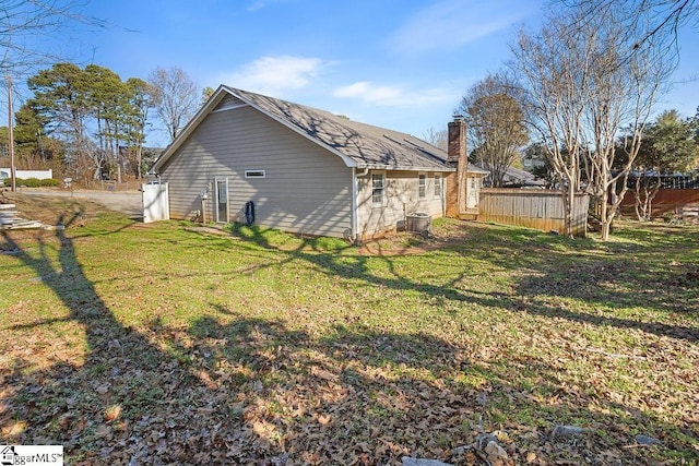 view of side of home with a lawn and central AC