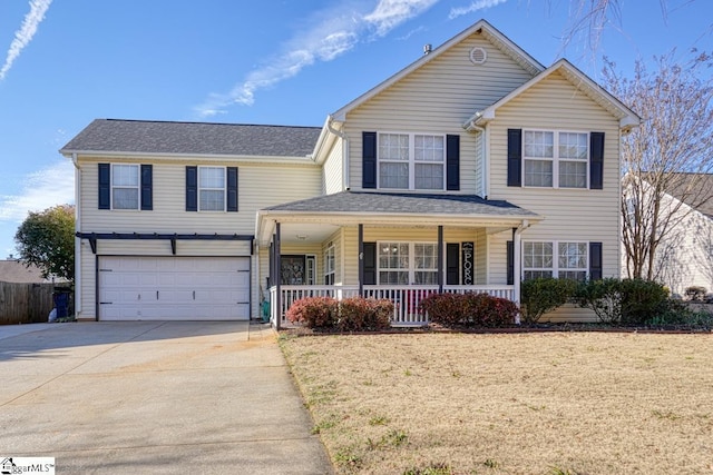 view of front of property featuring a porch, a garage, and a front lawn