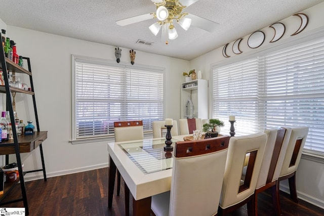 dining room with a textured ceiling, ceiling fan, and dark hardwood / wood-style floors