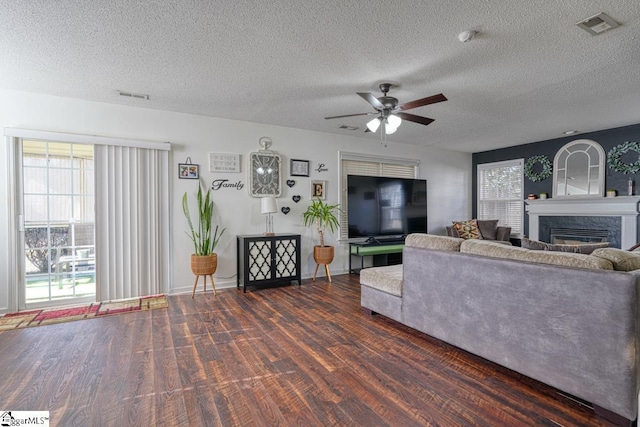 living room with ceiling fan, dark hardwood / wood-style flooring, and a textured ceiling