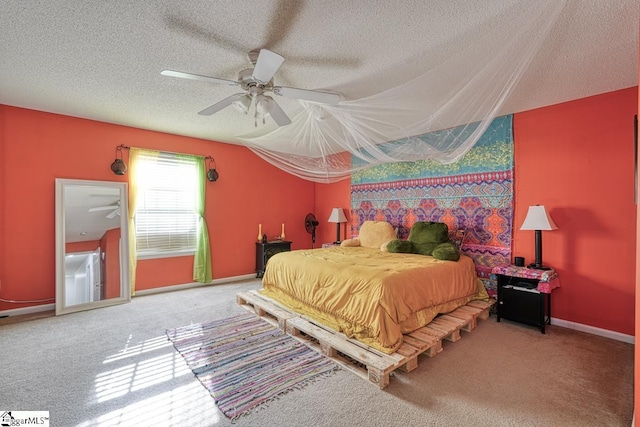 carpeted bedroom featuring ceiling fan and a textured ceiling