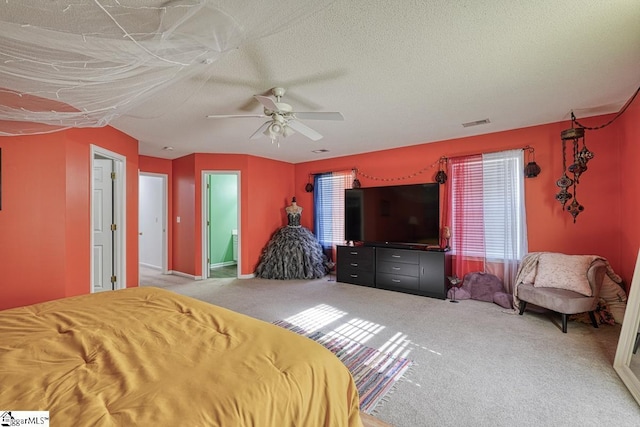 bedroom featuring carpet flooring, ensuite bathroom, ceiling fan, and a textured ceiling