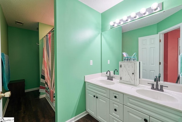 bathroom with vanity, a textured ceiling, and walk in shower