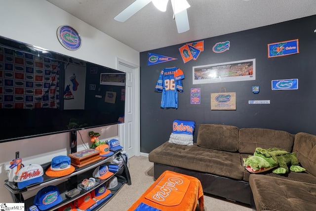 carpeted living room featuring ceiling fan and a textured ceiling