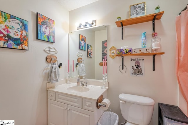 bathroom featuring vanity, a textured ceiling, and toilet