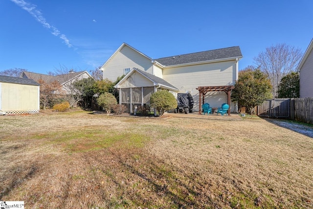 back of house with a pergola, a sunroom, and a lawn