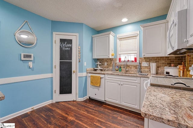 kitchen with white appliances, white cabinets, sink, a textured ceiling, and dark hardwood / wood-style flooring