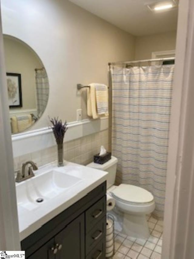 bathroom featuring vanity, tile patterned floors, a shower with shower curtain, decorative backsplash, and toilet