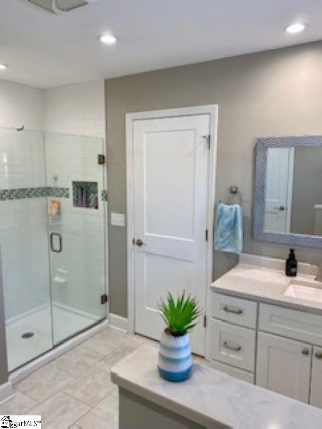 bathroom featuring tile patterned floors, vanity, and an enclosed shower