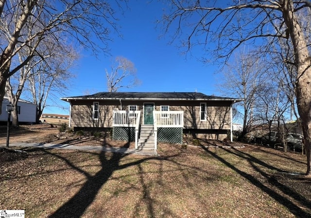 ranch-style home with a front lawn and a wooden deck