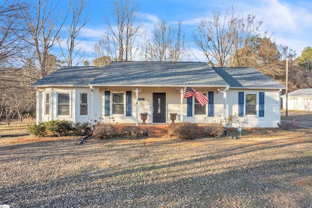 ranch-style home with covered porch and a front yard