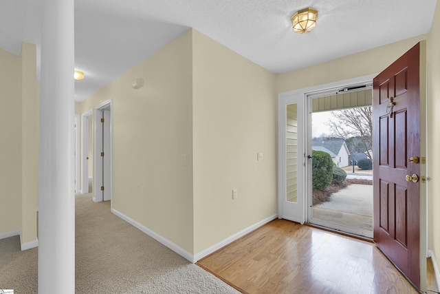 carpeted entryway with a textured ceiling