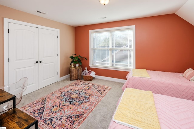 bedroom featuring light colored carpet, a closet, and lofted ceiling