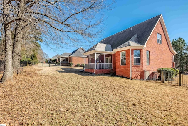 view of side of property with a sunroom and a yard