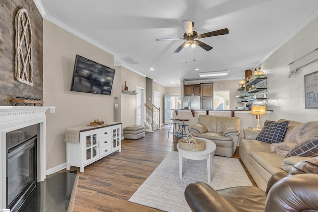 living room with ceiling fan, dark hardwood / wood-style flooring, wooden walls, and ornamental molding