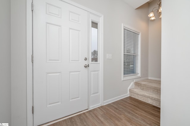 entryway featuring an inviting chandelier and light hardwood / wood-style flooring