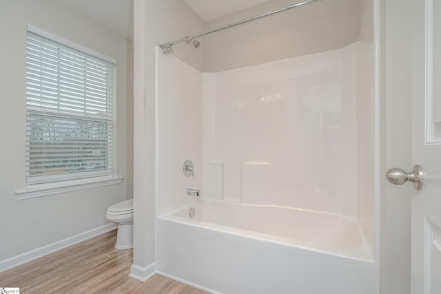 bathroom with toilet, hardwood / wood-style floors, and bathing tub / shower combination