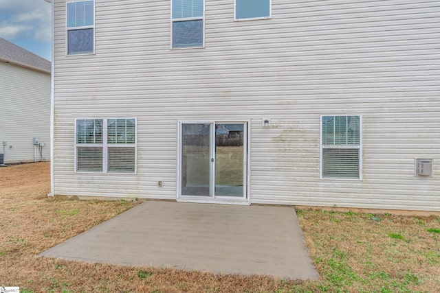 rear view of property featuring a lawn and a patio area