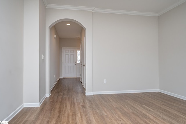 unfurnished room featuring light wood-type flooring and crown molding