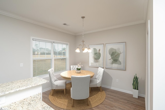 dining space featuring a chandelier, hardwood / wood-style floors, and ornamental molding