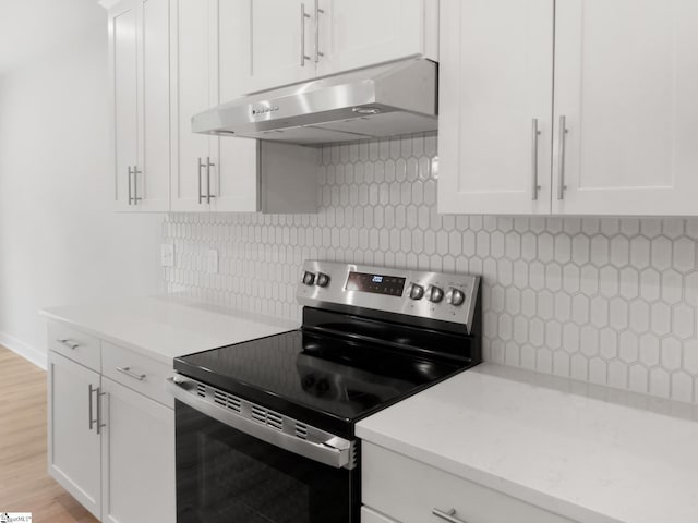 kitchen with white cabinetry, light wood-type flooring, electric stove, and tasteful backsplash