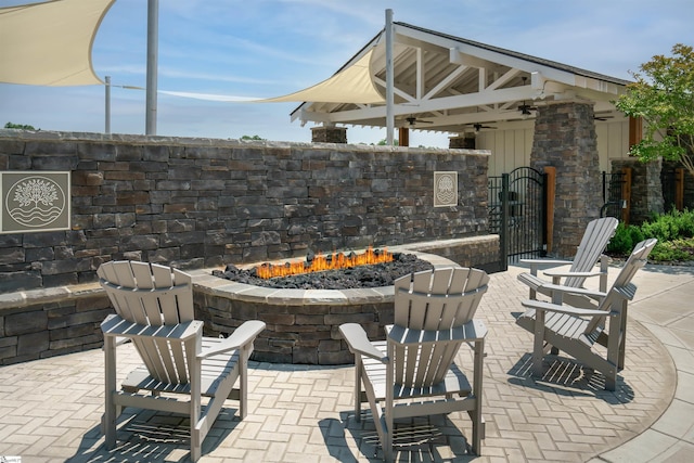 view of patio / terrace with a fire pit, ceiling fan, and a gazebo