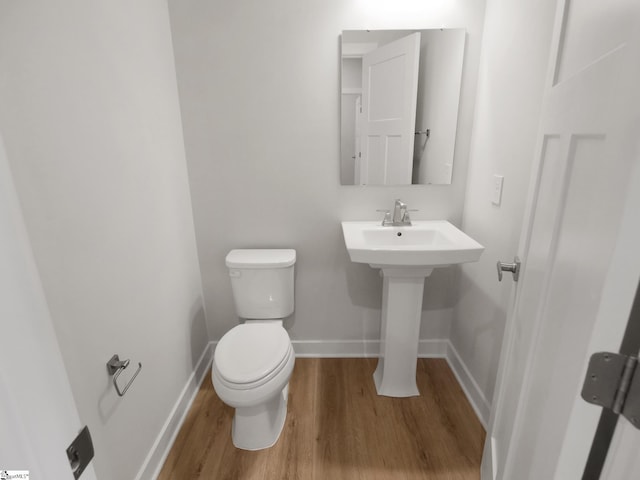 bathroom featuring wood-type flooring and toilet